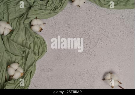 Grünes Tuch, Baumwollpflanzen. Weißer strukturierter Hintergrund. Grußkarte Kopierraum, Rahmen, Platz zum Hinzufügen von Text, Design, Hintergrund, Umschlag Stockfoto