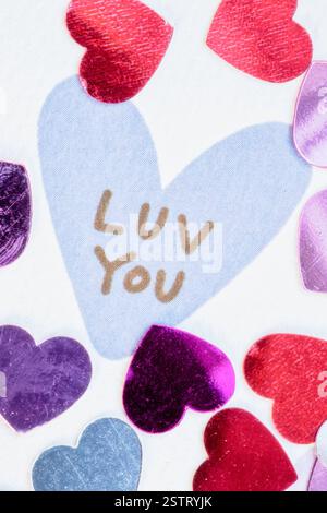 Nahaufnahme einer Valentinskarte mit Miniaturherzen und der Aussage „Luv You“, USA, 2025 Stockfoto
