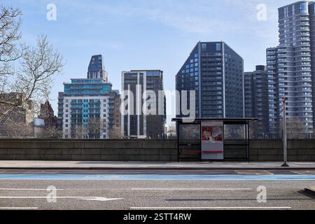14. Februar 2025 - London Großbritannien: Londoner Bushaltestelle und Bushaltestelle, ohne Busse, mit modernen Wohnblocks im Hintergrund Stockfoto