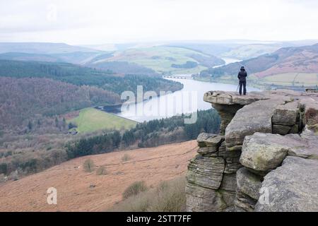 Ein Fotograf, der die dramatische Aussicht vom Bamford Edge im Peak District genießt. Stockfoto