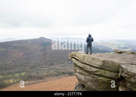 Ein Wanderer, der die dramatische Aussicht vom Bamford Edge im Peak District genießt. Stockfoto