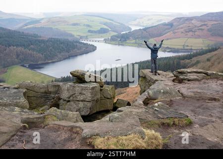 Ein Wanderer, der die dramatische Aussicht vom Bamford Edge im Peak District genießt. Stockfoto
