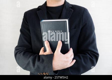 Die Heilige Bibel in den Händen der Männer. Der Begriff Glaube und Religion. christlicher Glaube. Der Priester hat ein Buch. Stockfoto