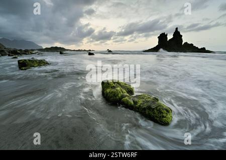 Dramatisch bewölkte Atmosphäre mit Felsformationen bei aufsteigender Flut bei Sonnenuntergang am Strand von Playa de Benijo, Teneriffa, Kanarischen Inseln, Spanien, Europa Stockfoto