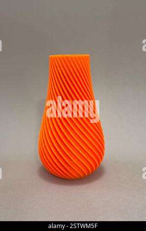 Kunstobjektvase, gedruckt auf 3D-Drucker aus geschmolzenem orangefarbenen Kunststoff. 3D-Druckrecycling mit fortschrittlicher Technologie Stockfoto