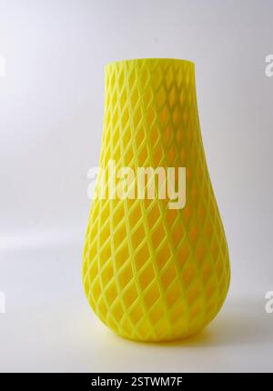Gelbes Kunstobjekt Blumenvase Wohndekor gedruckt auf 3D-Drucker aus geschmolzenem orangenem Kunststoff. 3D-Druckrecycling mit fortschrittlicher Technologie Stockfoto