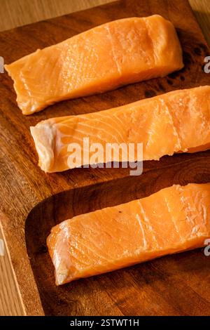 Rohe Lachsfilets auf einem Holzteller Stockfoto