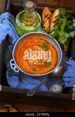 Kürbispüree Suppe mit geröstetem Baguette auf einem Holztablett Stockfoto