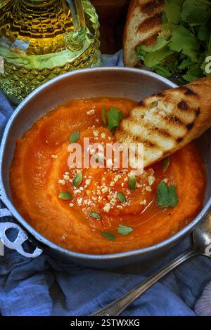 Kürbispüree Suppe mit geröstetem Baguette auf einem Holztablett Stockfoto