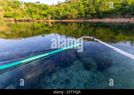 Banca schwimmt auf klarem Flachwasser mit sichtbaren Korallen an einem beliebten Tauchplatz in Busuanga, Philippinen Stockfoto