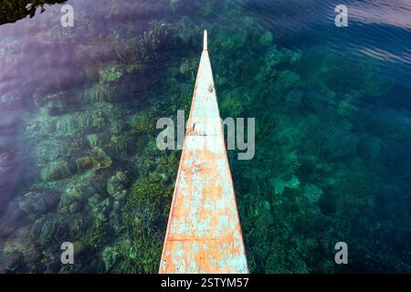 Banca schwimmt auf klarem Flachwasser mit sichtbaren Korallen an einem beliebten Tauchplatz in Busuanga, Philippinen Stockfoto