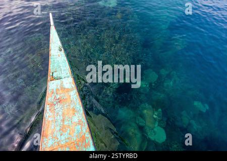 Banca schwimmt auf klarem Flachwasser mit sichtbaren Korallen an einem beliebten Tauchplatz in Busuanga, Philippinen Stockfoto