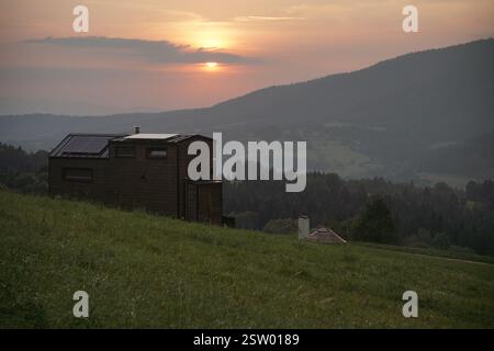 Modulhaus auf Rädern mit Außensauna und Sprudelbad oder Whirlpool auf der Natur mit Berghügel Hintergrund im Wald. Entspannte Atmosphäre Stockfoto