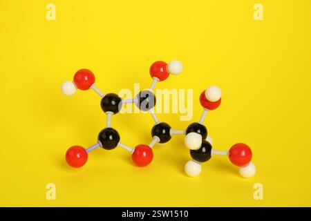 Molekül von Vitamin C auf gelbem Hintergrund. Chemisches Modell Stockfoto