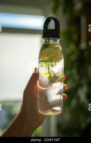 Wasser mit Minze, Thymian, Limette zum Trinken im Freien bei heißem Wetter, Flasche mit Minze und Zitronenwasser Stockfoto