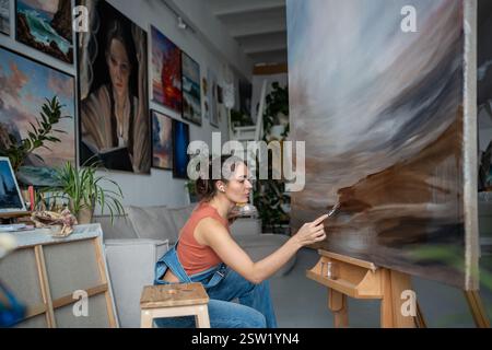 Professionelle Künstlerin in Lichtkunststudio, Malerei Bild. Porträt einer kreativen Malerin. Stockfoto