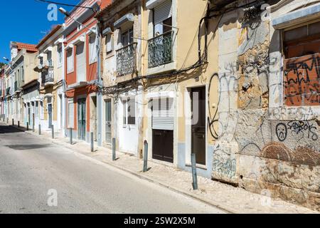 . Eine typische alte europäische Straße, eng mit ihren alten Gebäuden, europäische Stadt. Ein Stadtbild von Setúbal mit bunten Häusern und einem verlassenen Haus Stockfoto