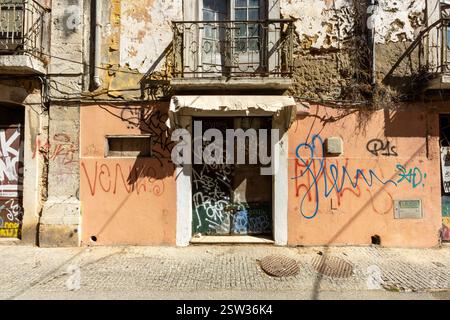 Ein altes verlassenes Haus in einer Straße von Setúbal. In den Farben Ocker, Braun, Lachs und weiß. Beschädigte Wände. Stockfoto