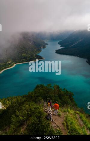 Atemberaubender Blick auf den Plansee, umgeben von nebeligen Bergen in Österreich Stockfoto