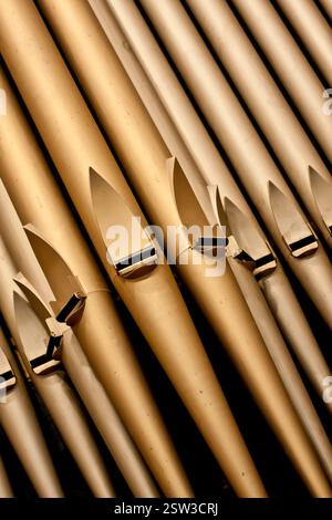 Eine Reihe von Metallrohren mit einem goldenen Farbton. Die Rohre sind so angeordnet, dass sie ein Gefühl von Tiefe und Textur erzeugen. Die Szene ist eine von Eleganz und Raffinesse Stockfoto