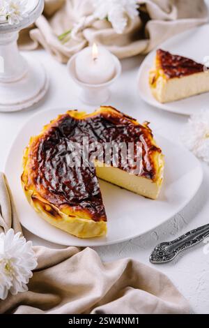 Traditionelle baskische Käsekuchenscheibe mit gebranntem san sebastian auf elegantem Tisch Stockfoto