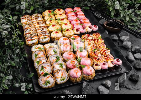 Verschiedene Sushi-Platte auf dunklem Steinhintergrund Stockfoto