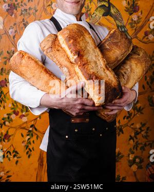 Handwerklicher Bäcker, der frisch gebackene Brotlaibe hält Stockfoto