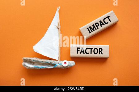 Symbol für Aufprallfaktor. Holzblöcke mit den Worten Impact Factor. Schöner oranger Hintergrund mit Boot. Business and Impact Factor Konzept. Kopierbereich. Stockfoto