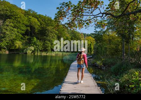 Wandern Sie entlang des hölzernen Gehweges an den Plitvicer Seen in Kroatien inmitten von lebhaftem Herbstlaub Stockfoto