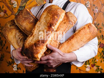 Handwerklicher Bäcker, der frisch gebackene Brotlaibe hält Stockfoto