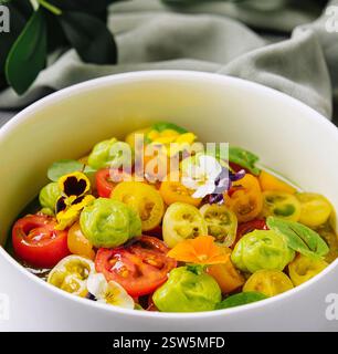 Frischer Tomatensalat mit essbaren Blumen Stockfoto