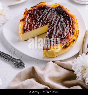 Traditionelle baskische Käsekuchenscheibe mit gebranntem san sebastian auf elegantem Tisch Stockfoto