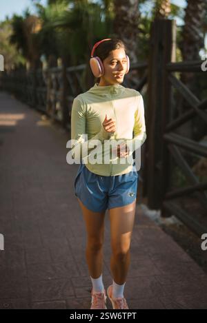 Eine junge Frau genießt gerne Musik und macht einen angenehmen Spaziergang in der wunderschönen Natur Stockfoto