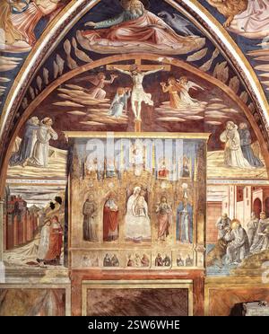 GOZZOLI, Benozzo (* ca. 1420, Firenze, d. 1497, Pistoia) Madonna und Kind umgeben von Heiligen 1452 Fresco San Francesco, Cappella di San Gerolamo, Montefalco nach Abschluss des Zyklus des hl. Franziskus malte Benozzo die erste Bucht im südlichen Seitenschiff der Klosterkirche, bekannt als Kapelle des hl. Jerome. Die Hauptwand zeigt ein gemaltes Polyptychon, die Madonna und das Kind umgeben von Heiligen. Dadurch entsteht die Illusion, dass sie sich in dem darüber gemalten Fresko fortsetzt, als wäre es eine realistische Ergänzung vor der Wand. Der Vorhang und die Schatten der Zinnen und Dreiecke Stockfoto