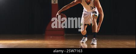 Erwachsener männlicher Basketballspieler, der Basketball hüpft. Muskulöser Basketballspieler mit klassischem Ball. Basketballtraining für Profispieler Stockfoto