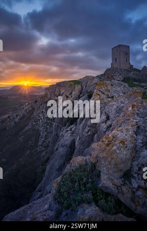 Sonnenuntergang im Schloss von La Estrella, Teba. Der antike Turm auf dem felsigen Gipfel, der dramatische Himmel und das goldene Licht über Andalusien Stockfoto