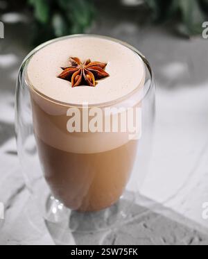 Gewürzter Latte in einem transparenten Glas auf strukturierter Oberfläche Stockfoto