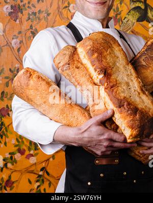 Handwerklicher Bäcker, der frisch gebackene Brotlaibe hält Stockfoto