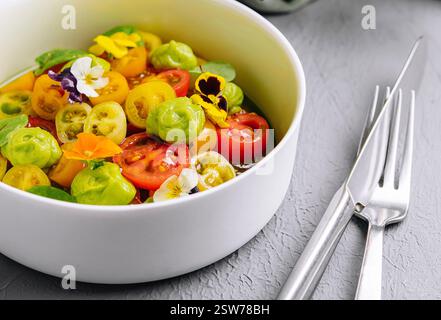 Frischer Tomatensalat mit essbaren Blumen Stockfoto
