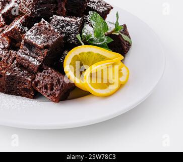 Schokoladen-Brownie-Stücke auf weißem Teller Stockfoto