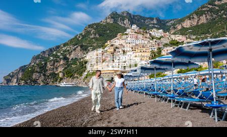 Schlendern Sie Hand in Hand entlang des wunderschönen Strands der Amalfiküste in Italien an einem lebhaften sonnigen Tag Stockfoto