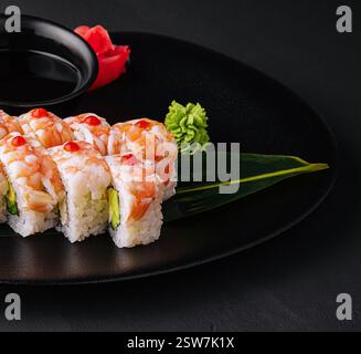 Sushi-Rolle mit Garnelenfleisch auf schwarzem Keramikplatte bedeckt Stockfoto