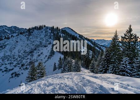 Verschneite Berglandschaft mit Sonnenschein über den Gipfeln bei Oberstdorf in den bayerischen Allgauer Alpen Stockfoto