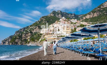 Schlendern Sie Hand in Hand am Strand in Positano an der wunderschönen Amalfiküste entlang Stockfoto