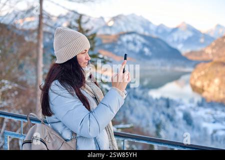 Dieses hochauflösende Foto zeigt eine junge Frau, die draußen in einer ruhigen, schneebedeckten Landschaft steht. Leicht links vom im positioniert Stockfoto