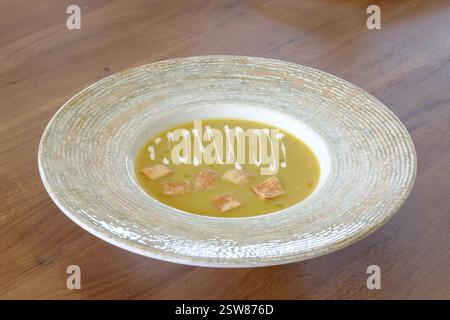 Cremige Suppe garniert mit knusprigen Croutons und einem Schuss Creme in einer stilvollen Schüssel Stockfoto
