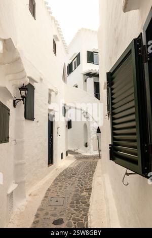 Enge Gassen des wunderschönen Dorfes Binibeca auf Menorca. Weiße verputzte Hauswände mit Holzelementen. Eine charmante Stadt in Spanien am Bale Stockfoto