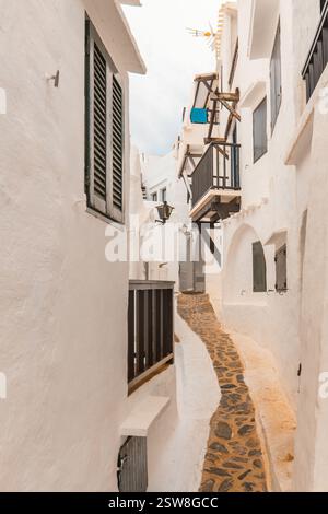 Enge Gassen des wunderschönen Dorfes Binibeca auf Menorca. Weiße verputzte Hauswände mit Holzelementen. Eine charmante Stadt in Spanien am Bale Stockfoto