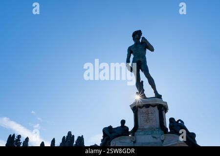 Vorderansicht der David-Statue am Piazzale Michelangelo in Florenz. Die Sonne der Morgendämmerung scheint am Fuß der Bronzestatue. Ein einzigartiges Werk und Stockfoto