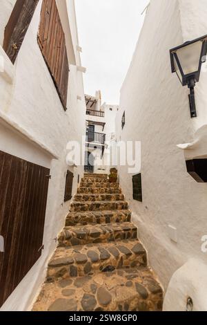 Die charmante Stadt Binibeca auf Menorca. Enge Gassen und weiße Wände von Häusern mit Holzelementen, mediterrane Architektur in Spanien Stockfoto
